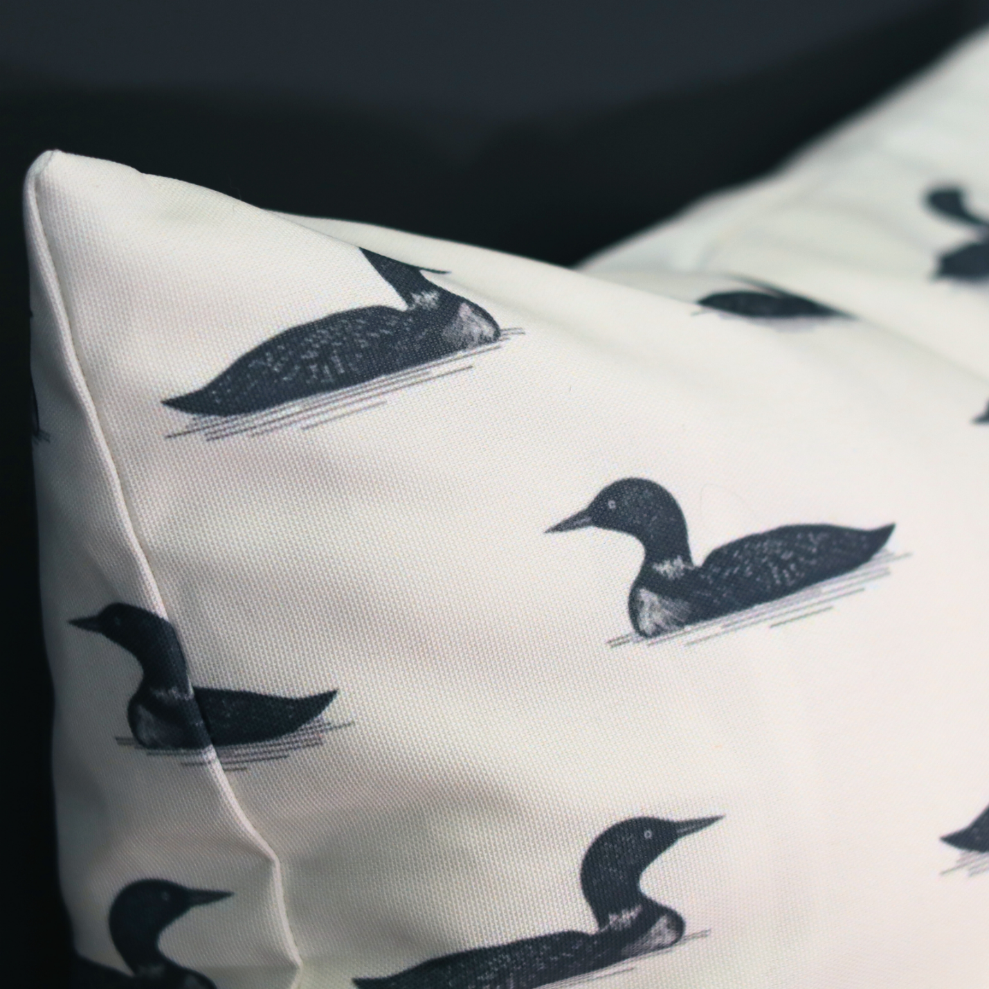 Pillow with black bird illustrations on a white background