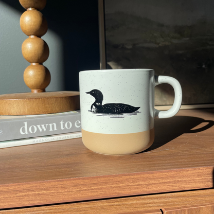 Mug with a loon design on a wooden surface