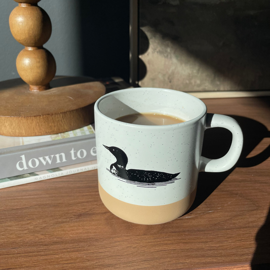 Mug with a loon design on a wooden surface