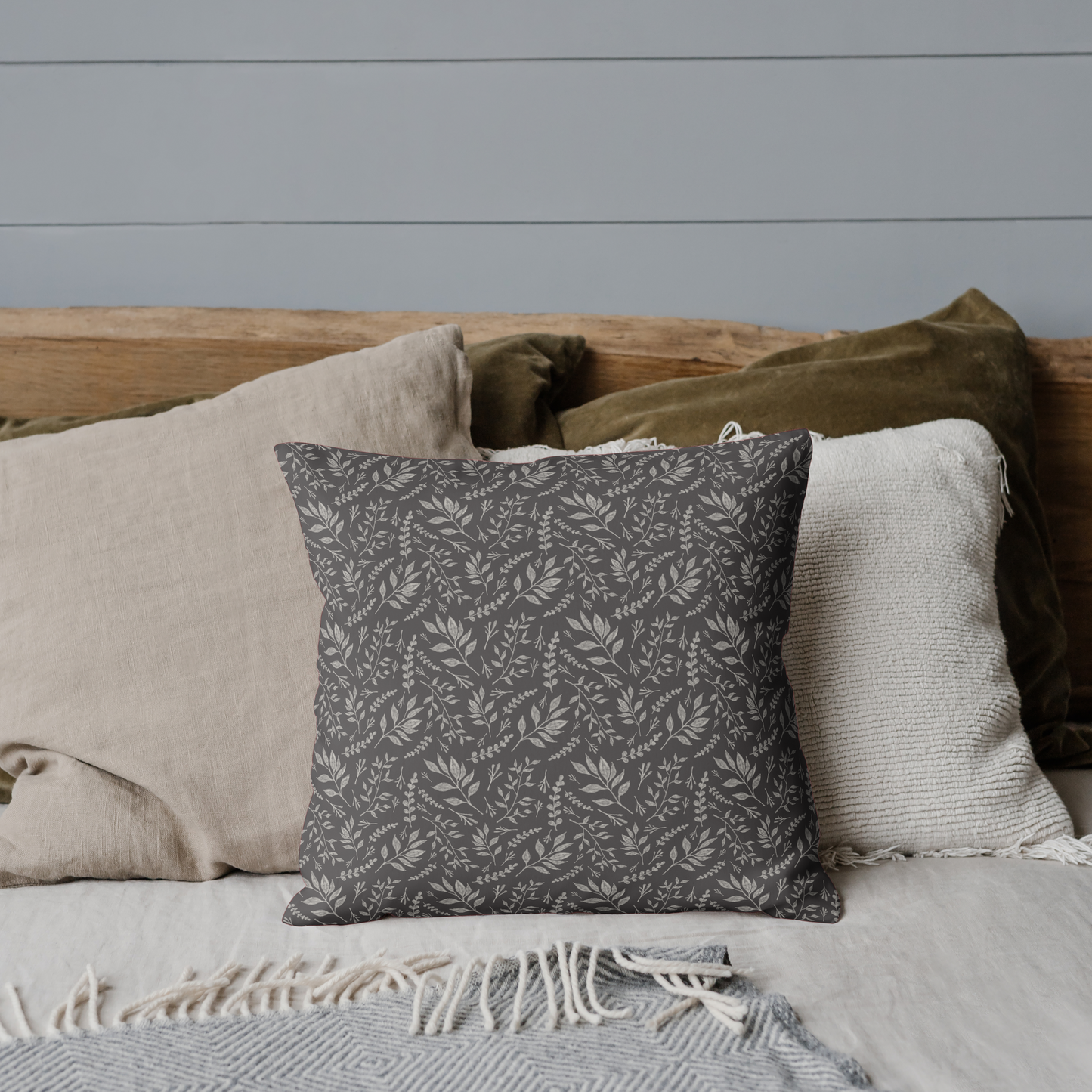 Decorative pillow with a pattern on a bed against a gray wall